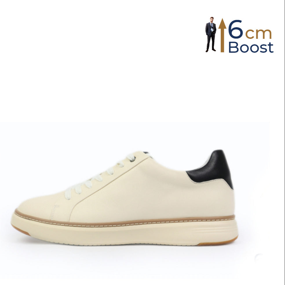 A pair of beige low-top sneakers with black accents and a lace-up closure. The sneakers have a crafted welt and appear to be lightweight with a rubber foam outsole.