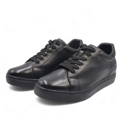 Pair of black leather sneakers on a white background
